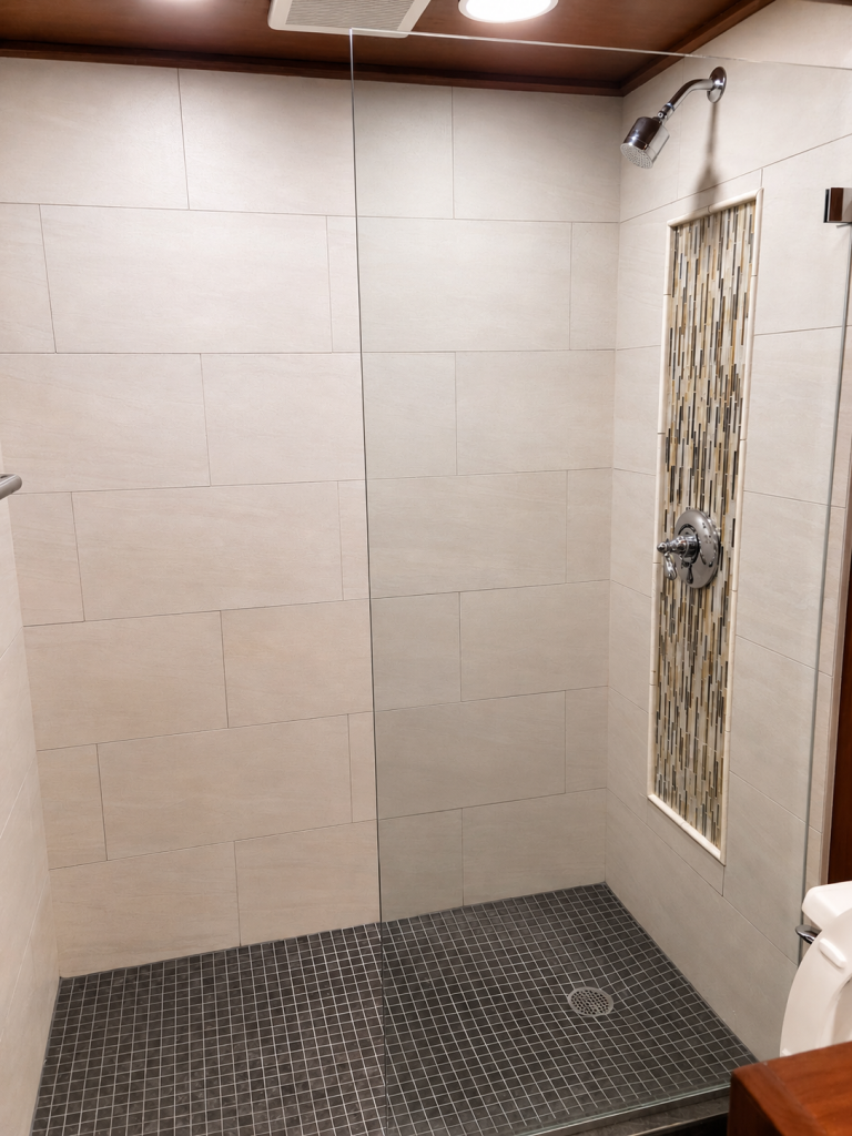 Beige walk-in shower with glass panel completed by Earth Smart Building and Remodeling